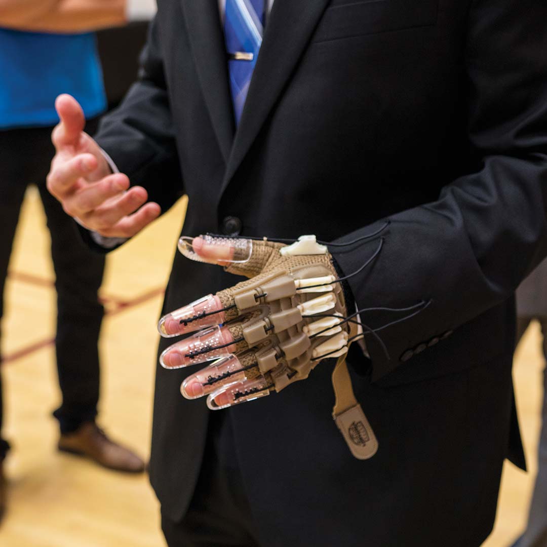 Medical device for a hand being demonstrated at a capstone symposium.