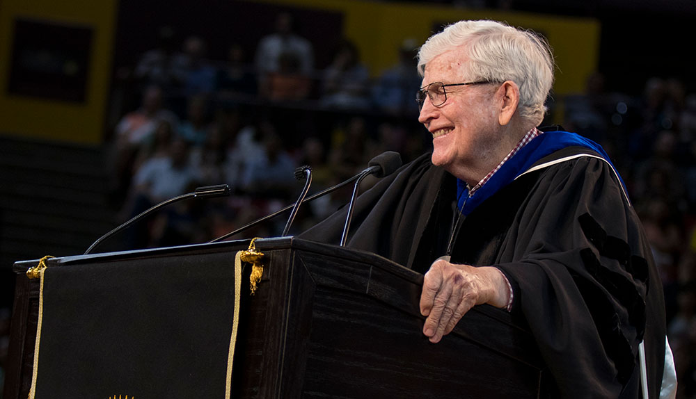 Ira A. Fulton stands at the podium during the ASU Engineering Convocation ceremony, smiling while he addresses the crowd.